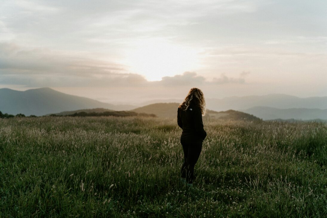 Woman sitting in natural light reflecting on God-given purpose beyond expectations